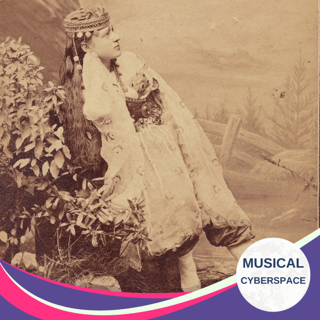 Sepia-toned image of a woman in an ornate, fairytale-style costume with long hair and floral embroidery, seated beside foliage in a painted woodland backdrop.