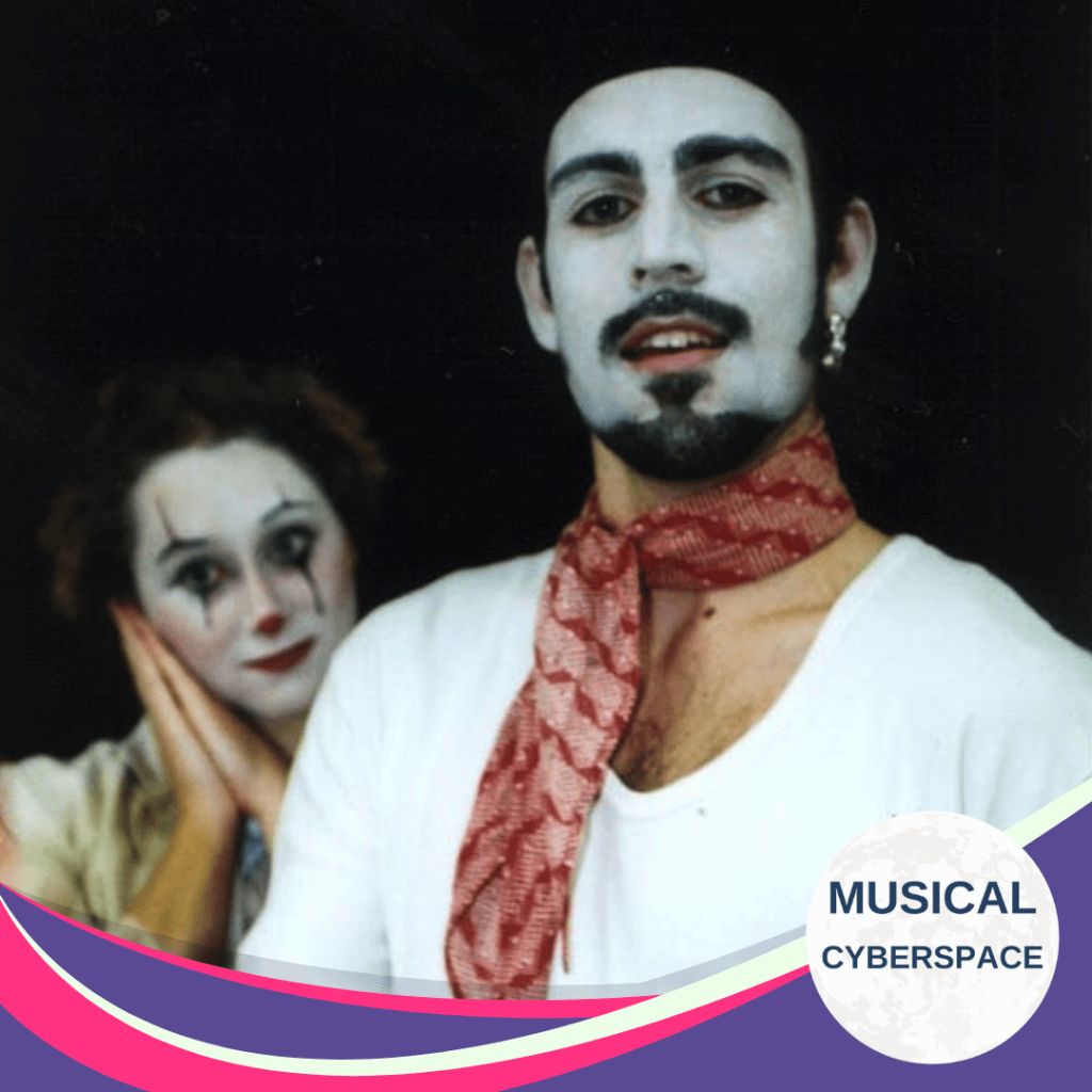 Two performers in mime-inspired makeup from UCT’s 2002 production of THE FANTASTICKS. The character in the foreground wears white face paint, a goatee, a patterned red scarf, and a hoop earring, while the character in the background rests her face in her hands with theatrical sadness painted on her expression.
