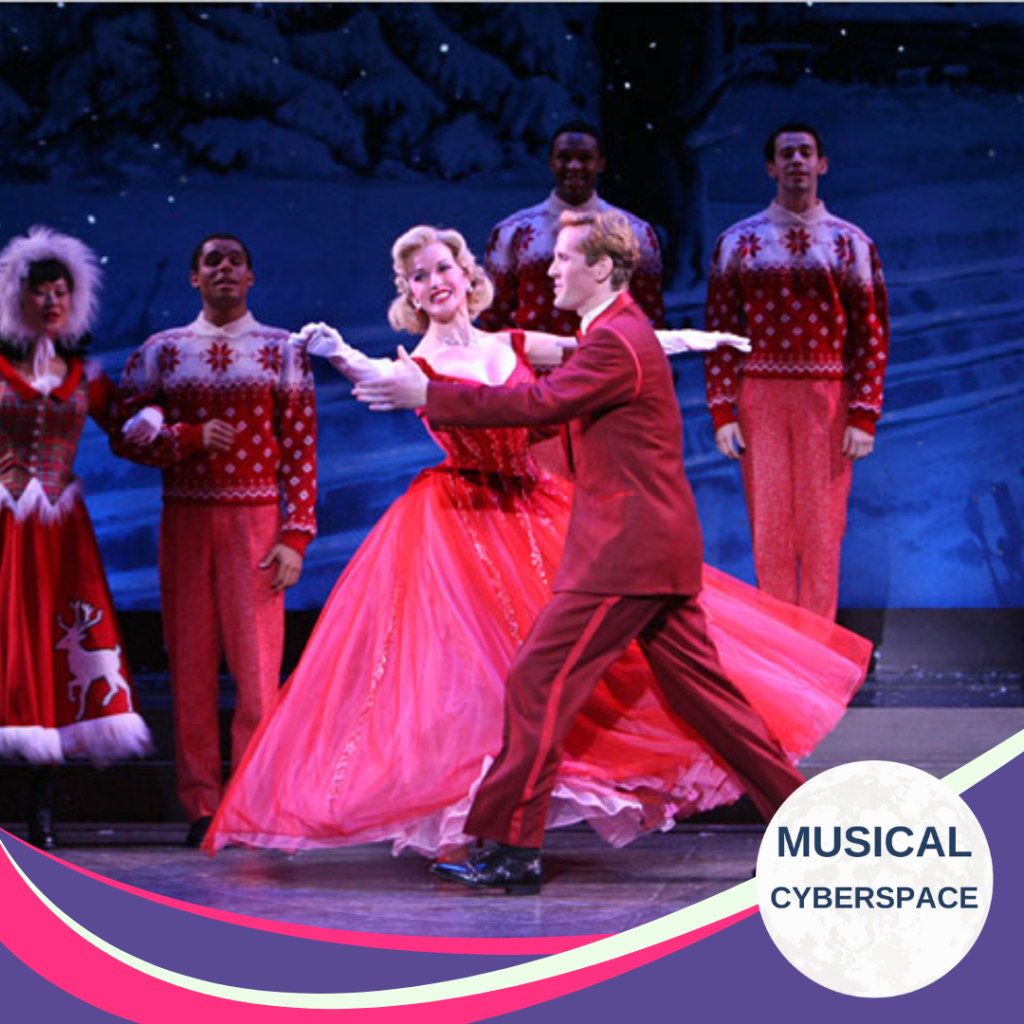 Meredith Patterson and Jeffry Denman dance together in elegant red costumes, flanked by a festive ensemble in red-and-white sweaters against a snowy winter backdrop.