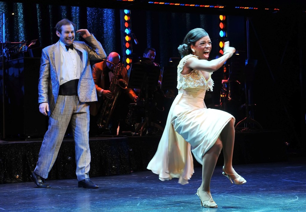 Chad Kimball as Huey Calhoun and Montego Glover as Felicia Farrell performing on stage in MEMPHIS, with live musicians and vibrant lighting evoking the energy of 1950s rock ’n’ roll.